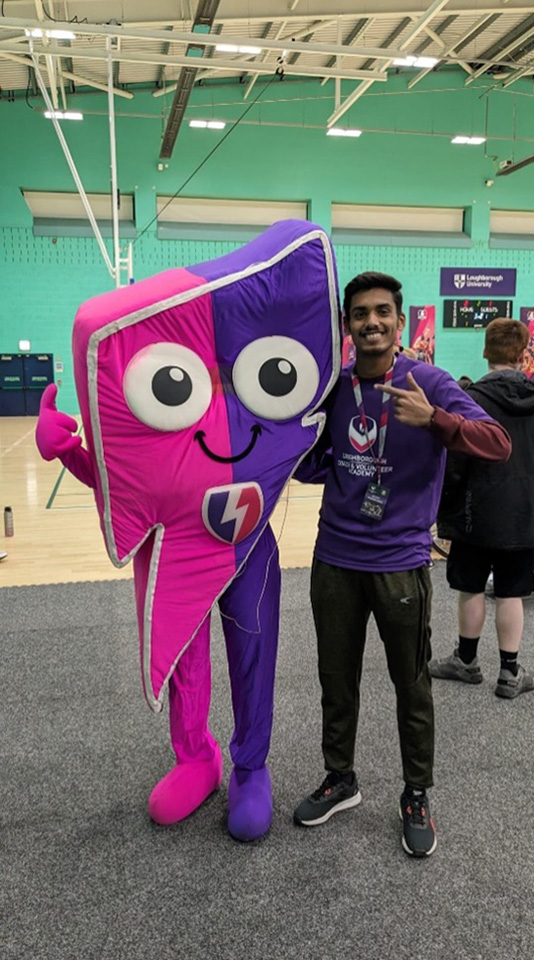 Student standing with mascot